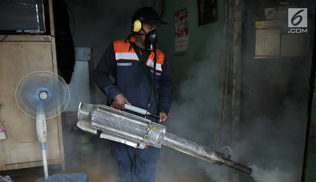 Petugas melakukan penyemprotan asap (fogging) nyamuk demam berdarah dengue (DBD) di salah satu rumah warga RW 01, Kelurahan Cipinang, Jakarta, Minggu (10/3). Fogging ini juga untuk membasmi perkembangbiakan jentik nyamuk. (merdeka.com/Iqbal Nugroho)
