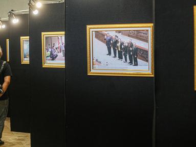 Sejumlah pengunjung mengamati karya dalam pameran Foto Warna-warni Parlemen ke XIII/2023 di Gedung Nusantara II, Jakarta, Rabu (12/7/2023). (Liputan6.com/Faizal Fanani)