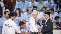 Capres nomor urut 1, Anies Baswedan menyalami capres nomor urut 3, Ganjar Pranowo di arena debat Capres 2024 di Kantor KPU, Jakarta Pusat, Selasa (12/12/2023) malam. (Liputan6.com/Faizal Fanani)