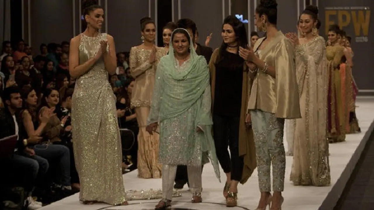Diapit sejumlah model, Mukhtar Mai tampil di atas catwalk mengenakan pakaian tradisional Pakistan berwarna hijau muda