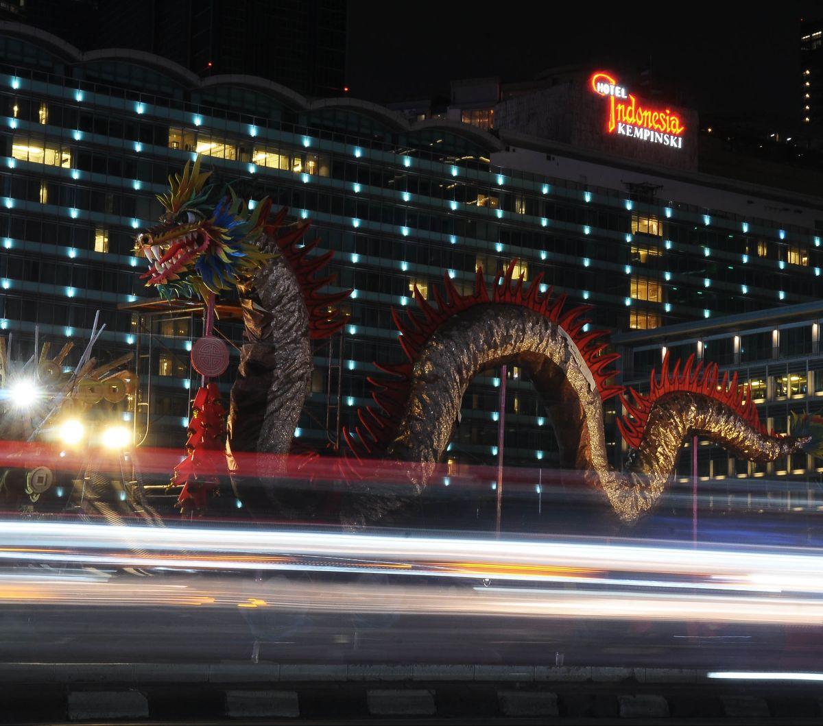 Ornamen naga kayu raksasa menghiasi kawasan Bundaran HI, Jakarta, pada 7 Februari 2024. Pemasangan instalasi tersebut dilakukan&nbsp;Dinas Pertamanan dan Hutan Kota (Distamhut) DKI Jakarta untuk menyemarakkan perayaan Imlek 2024.