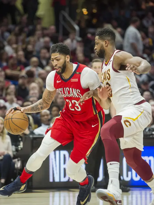 Pebasket New Orleans Pelicans, Anthony Davis, melewati pebasket Cleveland Cavaliers, Tristan Thompson, pada laga NBA di Quicken Loans Arena, Sabtu (31/3/2018). Cavaliers menang 107-102 atas Pelicans. (AP/Phil Long)