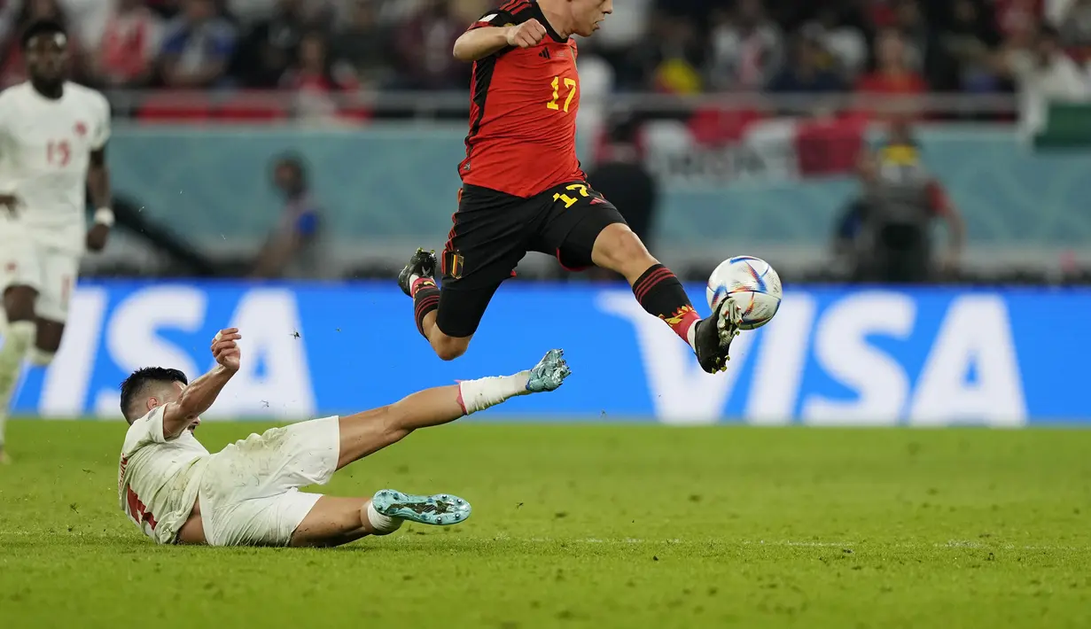 Penyerang Belgia, Leandro Trossard berusaha melewati pemain Kanada, Stephen Eustaquio pada pertandingan grup F Piala Dunia 2022 Qatar di Stadion Ahmad Bin Ali di Doha, Qatar, Kamis (24/11/2022). Belgia menang tipis atas Kanada 1-0. (AP Photo/Martin Meissner)