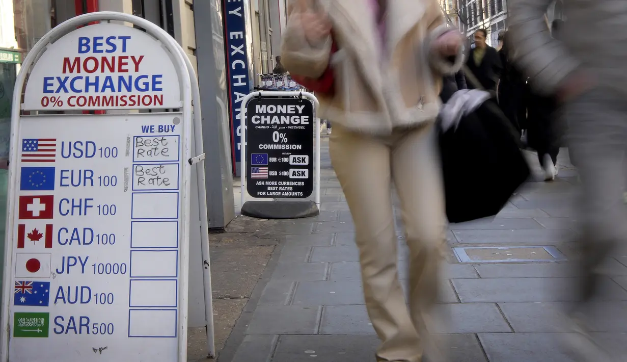 Pejalan kaki melewati pusat penukaran uang di Oxford Street di London, Rabu (15/2/2023). Inflasi Inggris mulai turun setelah sempat mencatatkan rekor inflasi tertinggi pada Oktober  mencapai 11,1%. (AP Photo/Kirsty Wigglesworth)