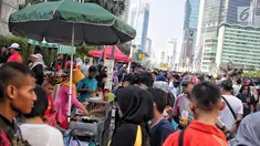 Pedagang kaki lima (PKL) berjualan saat pelaksanaan CFD di kawasan Bundaran HI, Jakarta, Minggu (5/5/2019). Kurangnya pengawasan petugas menyebabkan banyak PKL berjualan tidak pada tempat yang telah di sediakan Pemprov DKI sehingga mengganggu aktivitas warga berolahraga. (Liputan6.com/Faizal Fanani)