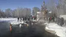 Orang-orang berjalan untuk mandi di air selama perayaan Epiphany tradisional karena suhu turun sekitar -24 derajat (-11,2 derajat Fahrenheit) di dekat biara Achairsky di luar kota Omsk di Siberia, Rusia (19/1/2021). (AP Photo/Evgeniy Sofiychuk)