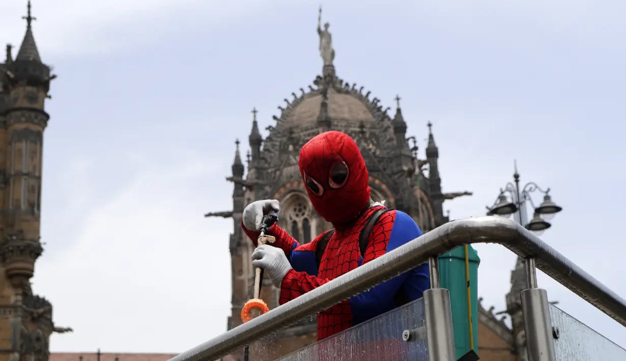 Pekerja sosial India Ashok Kurmi berpakaian seperti Spider Man mendesinfeksi daerah di sekitar stasiun kereta Chhatrapati Shivaji Maharaj selama lockdown yang diberlakukan di Mumbai, Rabu (21/4/2021). Kegiatan tersebut dilakukan untuk mengekang penyebaran COVID-19 di Mumbai. (AP Photo/Rajanish Kakad