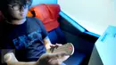 Penumpang Bus Harapan Jaya melakukan pijat elektrik di kursi belakang di Pool Ciputat, Tangerang Selatan. Bus dengan kapasitas 22 tempat duduk juga dilengkapi toilet dan smooking area. (Liputan6.com/Fery Pradolo)
