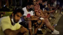 Puluhan fans berat Barca pun berkumpul di sekitar Stadion Camp Nou. Mereka tampak bersedih dan seakan tak percaya akan kehilangan sosok Lionel Messi yang akan meninggalkan klub kesayangannya Barcelona mulai musim depan. (Foto: AFP/Pau Barrena)