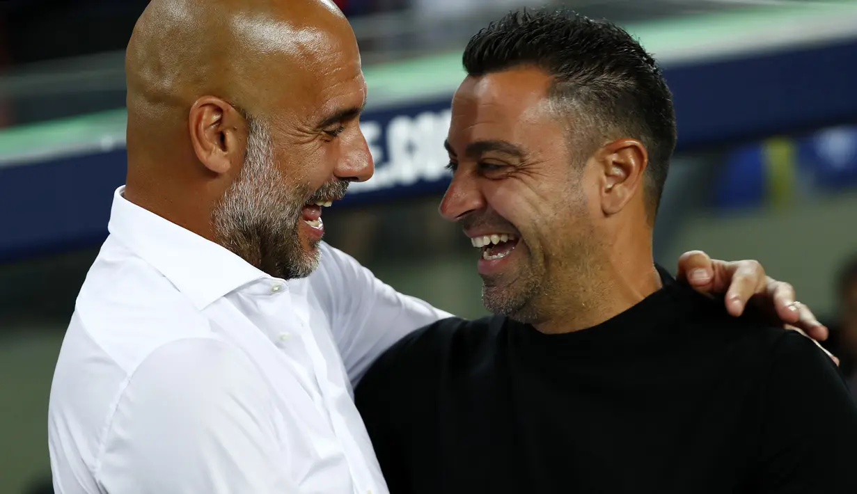 Laga amal Barelona melawan Manchester City yang berlangsung di Camp Nou, Kamis (25/08/2022), juga menjadi ajang reuni bagi Pep Guardiola dan Xavi Hernandez. (AP/Joan Monfort)