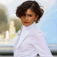 Zendaya melangkah ke show Louis Vuitton dengan potongan curly micro bob yang segar dan edgy.  [@zendayacit/@lesfacons].