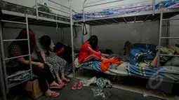 Sejumlah perempuan asal Tiongkok berada di sebuah kamar saat Polda Metro mengerebek rumah di kawasan Cilandak Timur, Jakarta, Kamis (7/5/2015).  Mereka diduga terlibat penipuan dengan modus cyber crime. (Liputan6.com/Faizal Fanani)