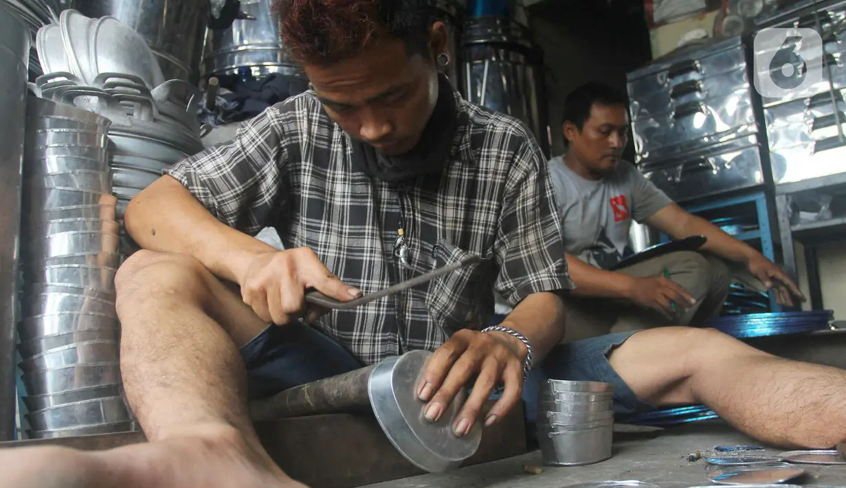 Seorang pengrajin membuat tempat cuci tangan di Pamulang, Tangerang Selatan, Banten  Minggu( 12/1/2020). Perabot tersebut dibuat dari bahan aluminium seperti dandang, oven, panci dan ventilator dijual dengan harga 100 sampai 300 ribu rupiah tergantung besar kecilnya. (merdeka.com/Arie Basuki)