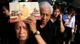 Pelayat berbaris memasuki Grand Palace untuk memberikan penghormatan terakhir kepada Raja Thailand Bhumibol Adulyadej di Bangkok, Jumat (14/10). Raja Bhumibol meninggal di usia 88 tahun. (Reuters/Jorge Silva)