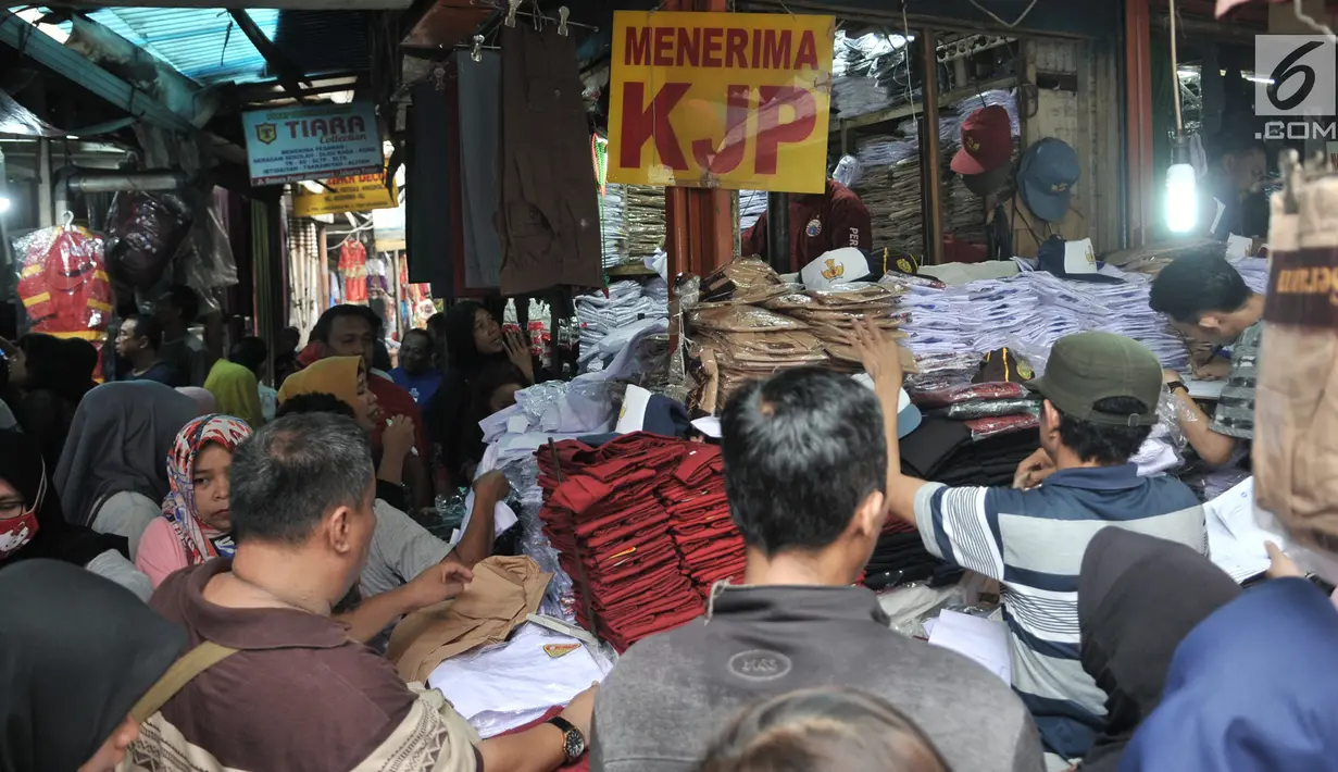 Keramaian saat para para orangtua mencari seragam sekolah di Pasar Jatinegara, Jakarta, Minggu (14/7/2019). Jelang tahun ajaran baru, Pasar Jatinegara ramai didatangi para orangtua yang mencari seragam sekolah untuk anaknya. (merdeka.com/Iqbal Nugroho)