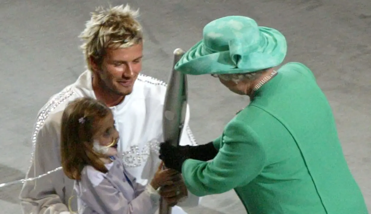 Pada 25 Juli 2002, David Beckham berkesempatan bertemu dengan Ratu Elizabeth II dalam acara upacara pembukaan Commonwealth Games 2002 di City of Manchester Stadium yang kini bernama Etihad Stadium. Saat itu David Beckham menjadi salah satu pengisi acara dalam upacara pembukaan tersebut. (AFP/Damien Meyer)