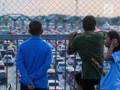 Warga melihat kemacetan arus lalu lintas di Gerbang Tol Utama Palimanan, Cirebon, Jawa Barat, Kamis (29/6). Menjelang sore hari warga berwisata sambil menyaksikan kemacetan volume kendaraan saat arus balik menuju Jakarta. (Liputan6.com/Faizal Fanani)