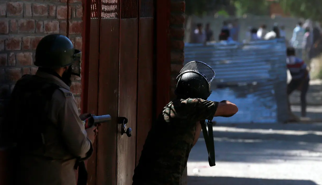 Polisi bersiap menembakkan gas air mata untuk membubarkan massa yang protes terhadap pembunuhan yang terjadi baru-baru ini di Kashmir, Jumat (5/8). (REUTERS / Danish Ismail)
