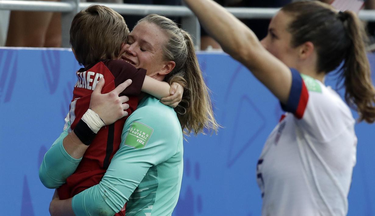 United States goalkeeper Alyssa Naeher holds a young boy as they celebrates at the end of the Women's World Cup round of 16 soccer match between Spain and US at the Stade Auguste-Delaune in Reims, France, Monday, June 24, 2019. US beat Spain 2-1. (AP Photo/Alessandra Tarantino)