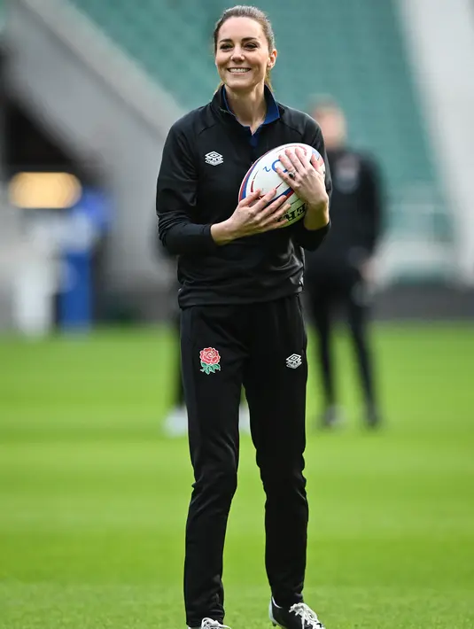 Kate Middleton, Duchess of Cambridge, bermain rugby saat sesi pelatihan tim rugby Inggris di Stadion Twickenham, London (2/2/2022). Kate akan bertemu dengan anggota regu putra dan putri menjelang Kejuaraan Enam Negara dan Piala Dunia Wanita di Selandia Baru pada musim gugur. (AFP/Justin Tallis)