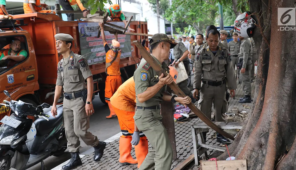 Petugas Satpol PP dan Pasukan Oranye membongkar lapak saat melakukan penertiban di kawasan pusat perbelanjaan Pasar Baru, Jakarta, Rabu (21/2). (Liputan6.com/Immanuel Antonius)