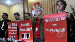 Pegiat anti korupsi yang tergabung dalam Koalisi Masyarakat Sipil Antikorupsi menunjukkan poster hentikan kriminalisasi KPK seusai melakukan konferensi pers menanggapi keputusan presiden di Gedung KPK, Jakarta, Kamis (19/2). (Liputan6.com/Johan Tallo)