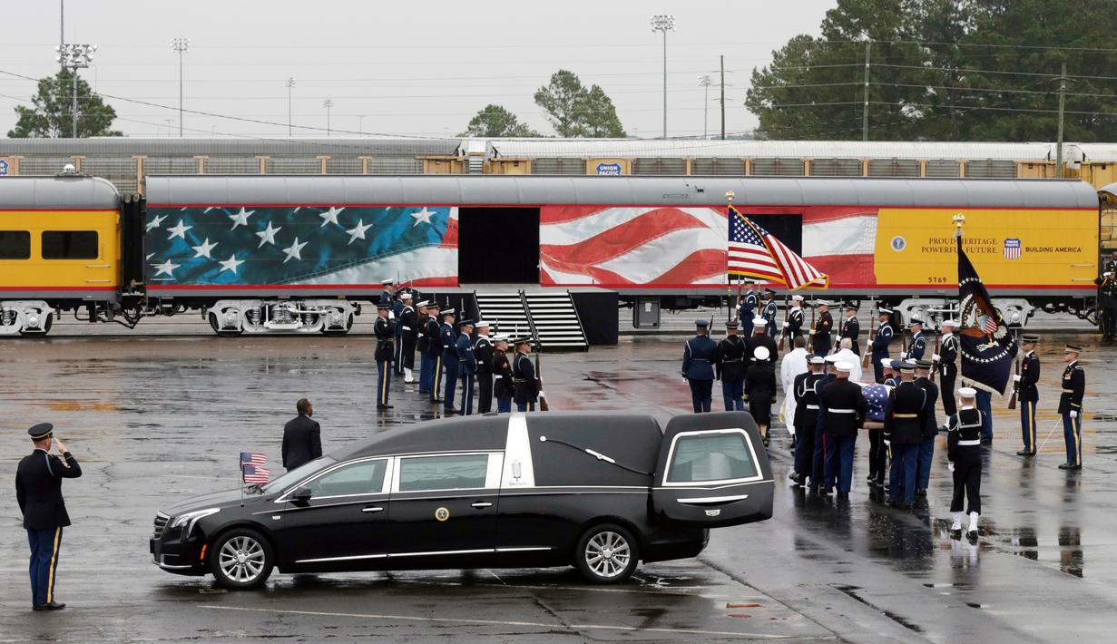 Anggota militer membawa peti jenazah Presiden ke-41 AS George HW Bush ke kereta di Union Pacific Westfield, Spring, Texas, Kamis (6/12). Kereta membawa jenazah George HW Bush menuju tempat peristirahatan terakhirnya. (AP Photo/Kiichiro Sato)