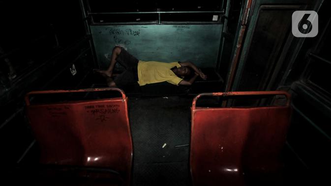 Beni (40), sopir Metromini 03 tidur di dalam bus saat menginap di pool. Karya foto ini sedang dipamerkan dalam pameran foto dengan tema 
