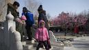Warga berjalan di sebuah jembatan di Ditan Park di Beijing (1/2). Tahun Baru Imlek jatuh pada 16 Februari tahun ini, dengan perayaan yang berlangsung selama seminggu di China. (AFP Photo/Nicolas Asfouri)