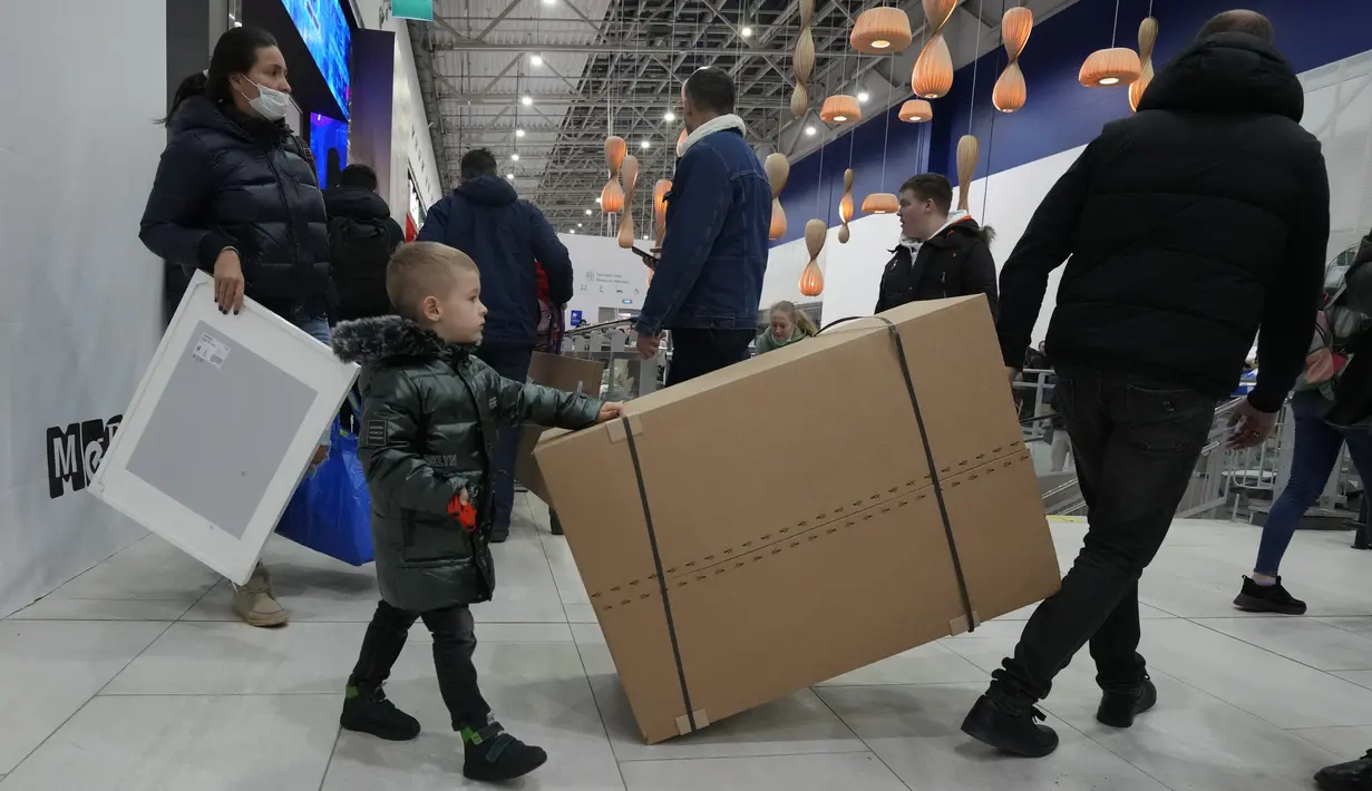 Orang-orang membawa pembelian mereka saat toko IKEA tutup di pinggiran St. Petersburg, Kamis (3/3/2022). Peritel IKEA menghentikan operasional di "Negeri Beruang Merah" dan Belarusia untuk sementara waktu mulai Jumat, 4 Maret 2022 buntut dari invasi Rusia ke Ukraina. (AP Photo/Dmitri Lovetsky)