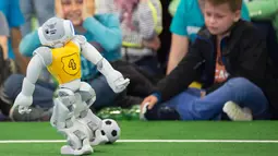 Aksi robot tim Jerman 'Nao Devils' mengendalikan bola pada ajang 'RoboCup German Open 2017' di Magdeburg, Jerman, Minggu (7/5). Sekitar 200 tim dengan 1000 peserta dari 15 negara mengikuti ajang kompetisi robot ini. (AP Photo/Jens Meyer)