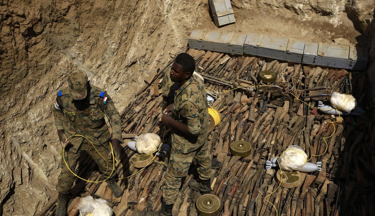 Tentara pemerintah Sudan menata senjata-senjata api milik warga sipil saat akan dihancurkan di Hajar Al Asal di Negara Bagian Sungai Nil, Sudan (29/9/2020). Penghancuran berlangsung di kawasan pangkalan Hajar Al Asal berjarak sekitar 200 kilometer ke utara dari Ibu Kota Khartoum. (AFP/Ashraf Shazly)