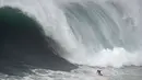 Peselancar Andrew Cotton dari Inggris mengendarai ombak selama kompetisi selancar ombak besar Nazare Tow Challenge di Praia do Norte, atau Pantai Utara, di Nazare, Portugal, Kamis, 10 Februari 2022. (AP Photo/Armando Franca)