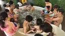 Petugas memberikan cokelat kepada pengunjung saat mandi spa cokelat di Hakone, Jepang, Senin (13/2). Mandi spa cokelat ini digelar setiap tahun bulan Februari. (AFP PHOTO / Kazuhiro Nogi)