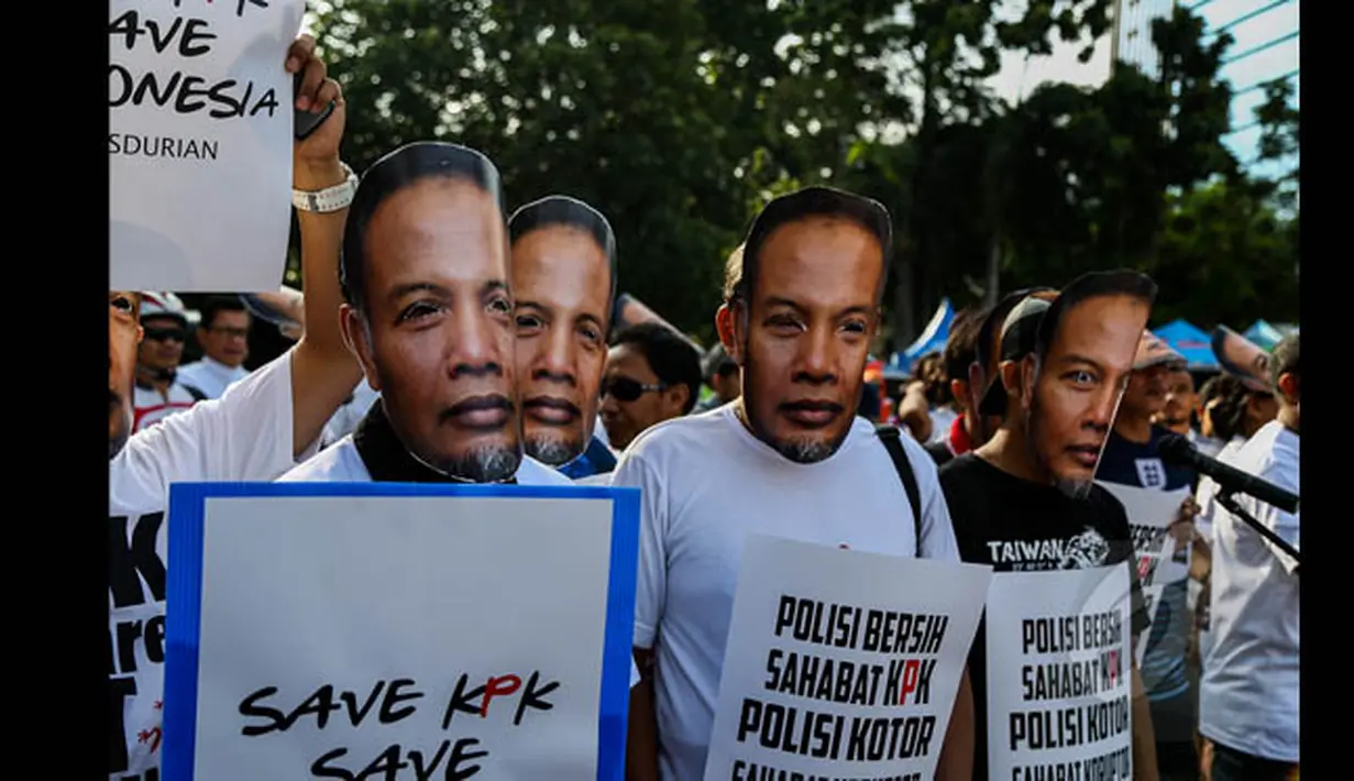 Puluhan orang yang menggunakan topeng wajah Wakil Ketua KPK, Bambang Widjojanto, saat menggelar aksi di kawasan Jalan Sudirman, Jakarta, Minggu (25/1/2015). (Liputan6.com/Faizal Fanani)