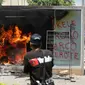 Mesin ATM bitcoin bernama Chivo terbakar selama protes terhadap kebijakan Presiden Nayib Bukele pada Hari Kemerdekaan di San Salvador, El Salvador, Rabu (15/9/2021). Ribuan warga juga memprotes Bukele yang dikhawatirkan kembali mengikuti pemilihan pada tahun 2024 mendatang. (MARVIN RECINOS/AFP)