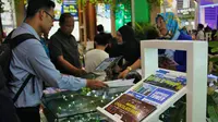 Konsumen tengah melihat promo yang ditawarkan pengembang properti dalam pameran.