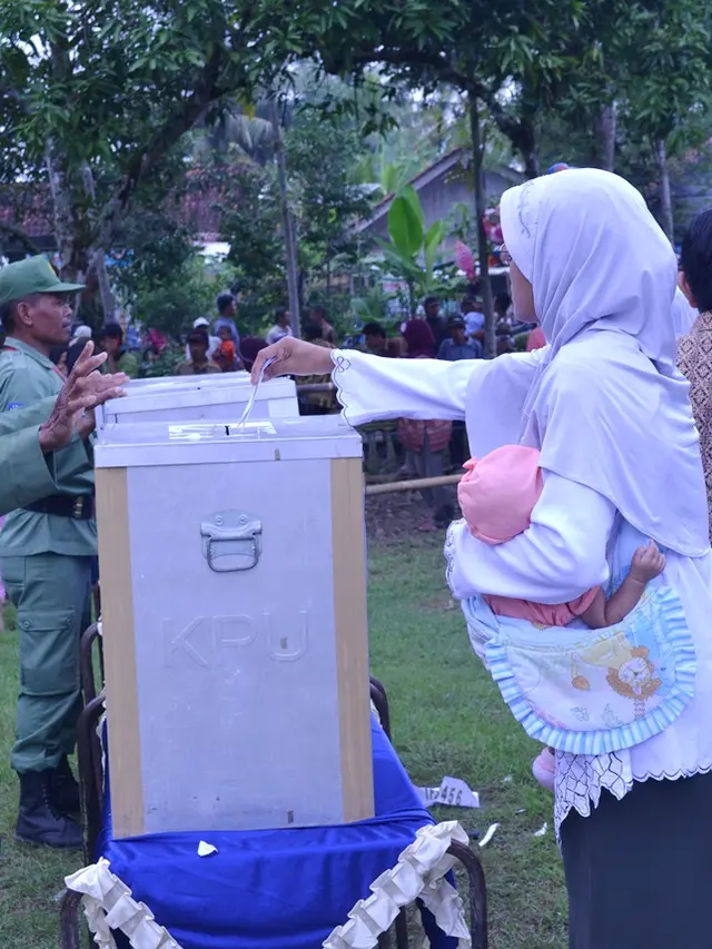 Ilustrasi - Seorang ibu yang menggendong bayinya menunaikan hak suaranya dalam Pemilu. (Foto: Liputan6.com/Muhamad Ridlo)