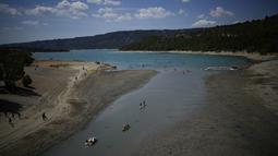 Orang-orang menikmati aktivitas air saat permukaan air terus menurun di Verdon Gorge, Prancis selatan (9/8/2022). Badan cuaca nasional Meteo France mengatakan, gelombang panas dimulai di selatan dan diperkirakan akan menyebar ke seluruh negeri dan berlangsung hingga akhir pekan.  (AP Photo/Daniel Cole)