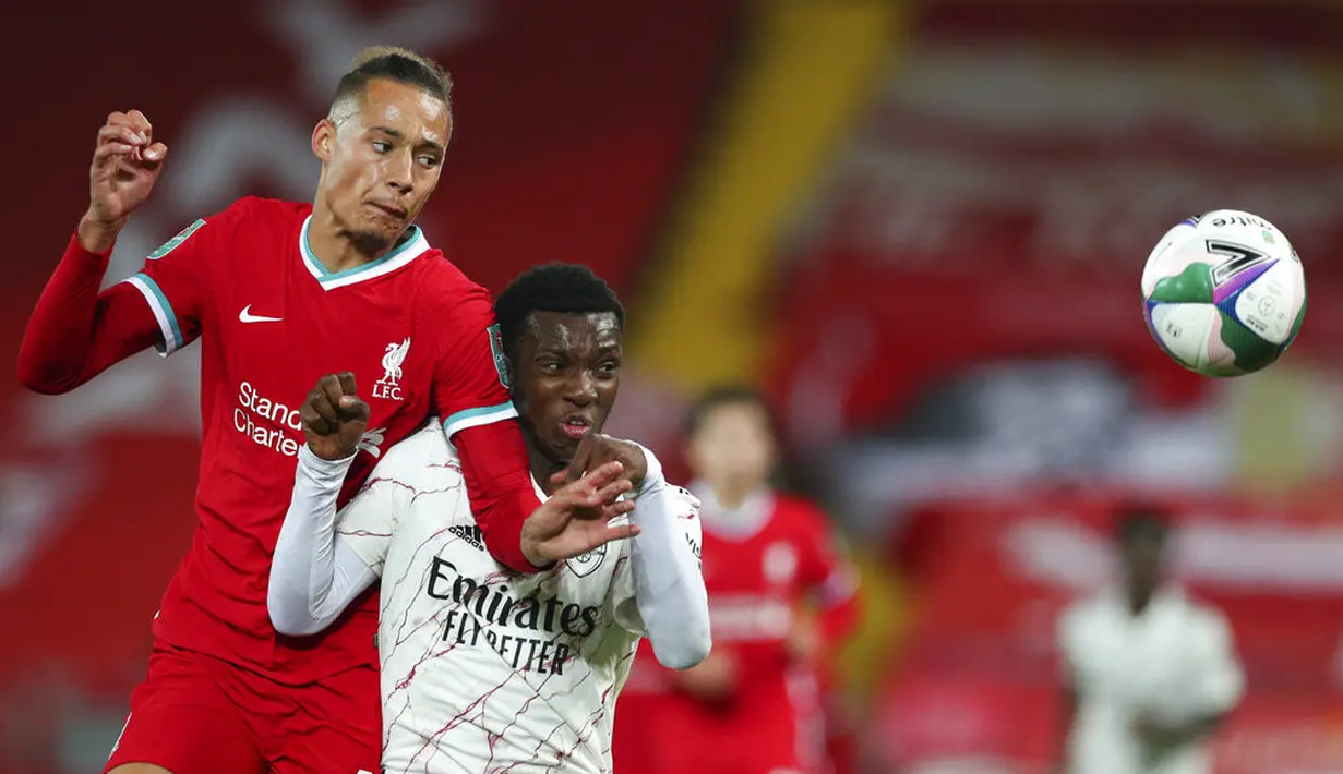 Pemain Liverpool Rhys Williams (kiri) dan pemain Arsenal Eddie Nketiah berebut bola pada pertandingan putaran keempat Piala Liga antara Liverpool dan Arsenal di Anfield, Liverpool, Inggris, Kamis (1/10/2020). Arsenal mengalahkan Liverpool 5-4 dalam adu penalti. (Peter Byrne/Pool via AP)
