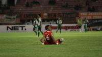 Pemain belakang Persija Jakarta, Maman Abdurrahman bersantai sejenak setelah pertandingan melawan PS TNI dihentikan karena matinya salah satu lampu Stadion Manahan, Solo, Selasa (15/12/2015). (Bola.com/Robby Firly)
