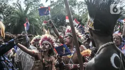 Pendukung partai politik mengenakan baju adat Papua saat turut meramaikan pawai di depan Kantor Komisi Pemilihan Umum (KPU) RI, Jakarta, Senin (1/8/2022). Sebanyak sembilan partai politik dijadwalkan turut meramaikan hari pertama Pendaftaran Peserta Pemilu 2024 yang dibuka mulai hari ini. (merdeka.com/Iqbal S. Nugroho)