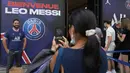 Turis AS Nancy Cornejo mengambil foto temannya Argilio Rodriguez dari New York yang mengenakan jersey bertuliskan nama Lionel Messi di luar toko resmi PSG di Paris, Rabu (11/8/2021). Penjualan jersey PSG dengan nama Messi dan nomor punggung 30 laris manis. (AP Photo/Francois Mori)