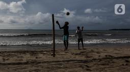 Dua anak laki-laki bermain bola di pantai Carita, Pandeglang, Banten, Selasa (18/1/2022). Objek wisata Pantai Carita yang menjadi tempat favorit pengunjung kini tampak sepi seusai gempa beberapa waktu lalui dan juga lantaran naikknya kasus virus covid 19 varian omicron. (Liputan6.com/Johan Tallo)