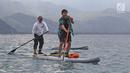 Direktur Utama Ketenagakerjaan, Agus Susanto dan Bupati Trenggalek, Mochammad Nur Arifin olah raga  Stand Up Paddle di Pantai Mutiara, Trenggalek, Jawa Timur, Sabtu (7/9/2019). (Liputan6.com/Herman Zakharia)