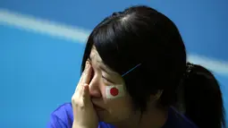 Salah satu warga Jepang di Tokyo menangis usai menyaksikan Keisuke Honda dkk dikalahkan Kolombia 1-4 di laga penutup penyisihan Piala dunia 2014 Grup C, (25/6/2014). (REUTERS/Issei Kato)