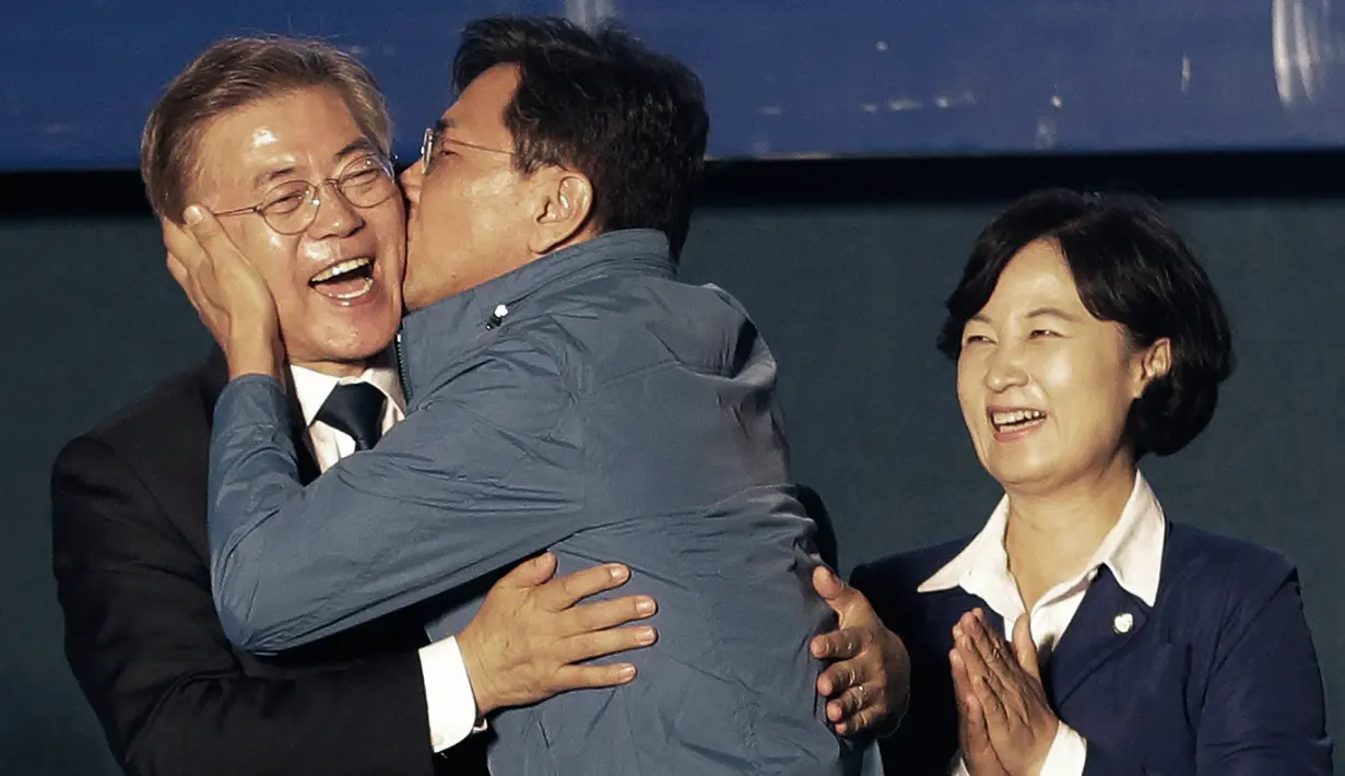 Kandidat Presiden Korsel, Moon Jae-in mendapat kecupan dari Gubernur Provinsi Chungcheong, Ahn Hee-jung sebelum menyampaikan pidato kemenangannya di Seoul, Selasa (9/5). Moon menang telak dengan megantongi 41,4 persen suara. (AP Photo/Ahn Young-joon)