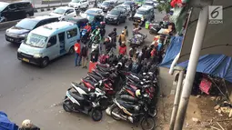 PKL dan parkir liar memadati trotoar serta bahu jalan di kawasan Pasar Senen, Jakarta, Kamis (7/2). Selain mengganggu pejalan kaki, kondisi tersebut juga menghambat arus lalu lintas. (Liputan6.com/Immanuel Antonius)