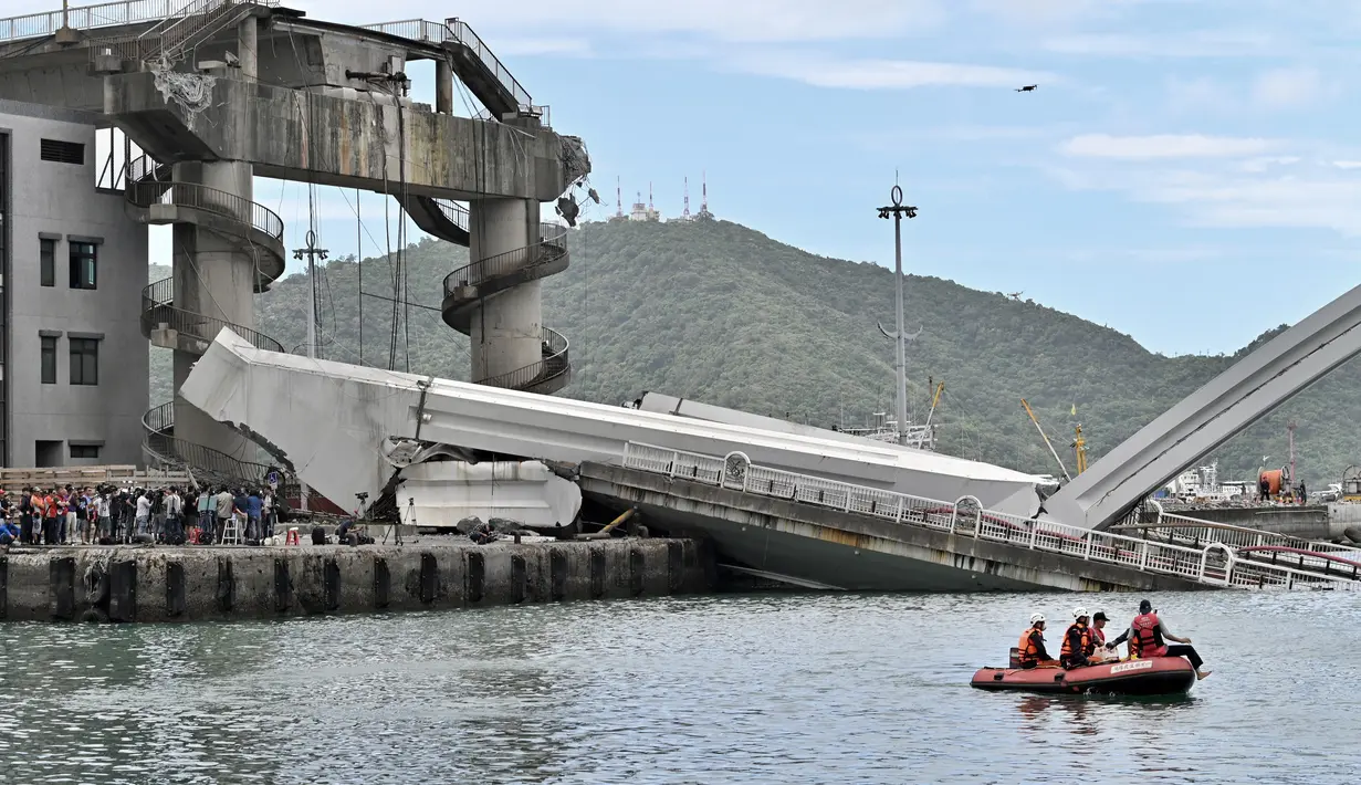 Tim penyelamat menggunakan kapal kecil bersiap mengevakuasi dalam pekerjaan kapal di lokasi jembatan yang ambruk di pelabuhan Nanfangao di kota Suao (1/10/2019). Dilaporkan beberapa nelayan diduga masih terjebak di perahu yang tertimpa material perahu ke dasar laut. (AFP Photo/Sam Yeh)