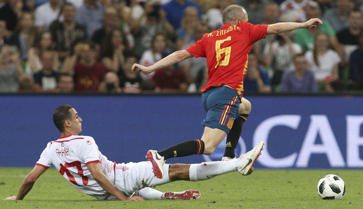 Pemain Spanyol, Andres Iniesta (kanan) melewati adangan pemain Tunisia, Ellyes Skhiri pada laga uji coba di Krasnodar stadium, Rusia, (9/6/2018). Spanyol menang 1-0. (AP/STR)